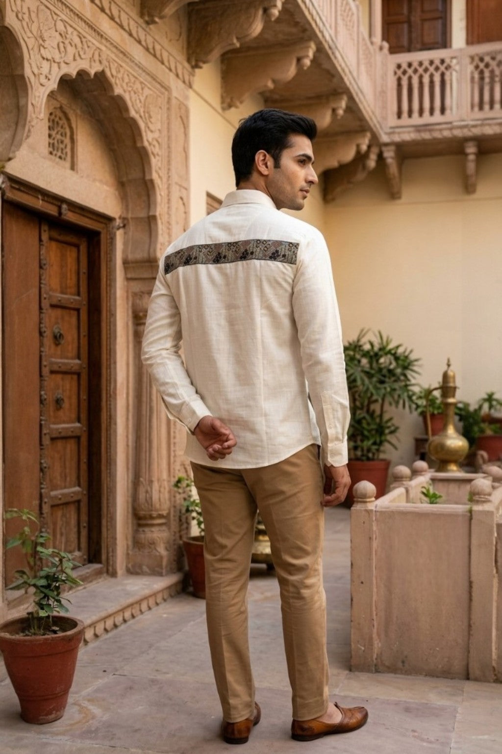Man wearing JHAROKA ACCENT MENS SHIRT, a off white hand-embroidered cotton-linen shirt from M R JAIPUR